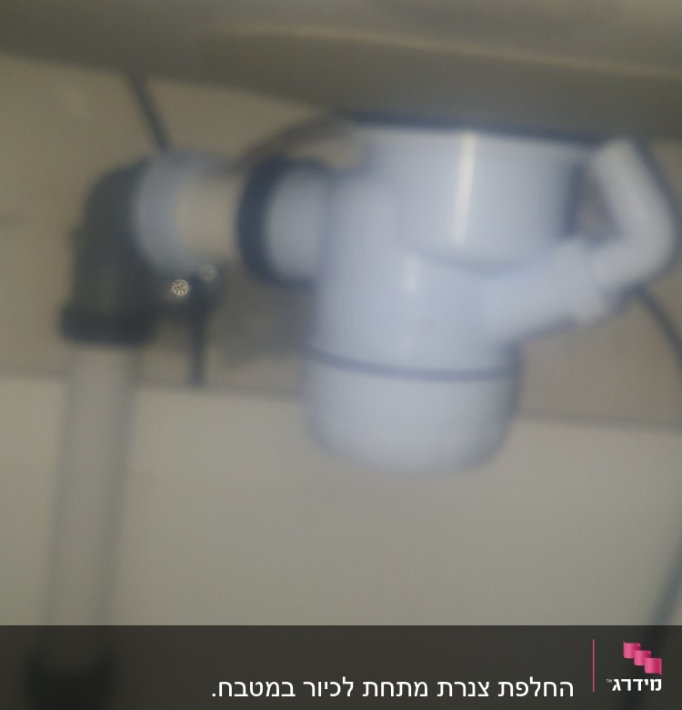 צינור פלסטיק לבן עם מחבר מתחת לכיור